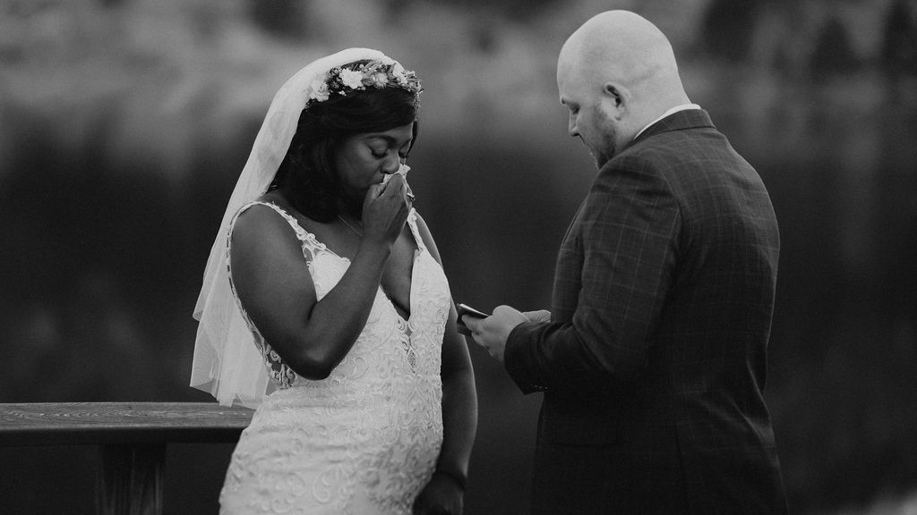 A bride cries while her groom reads his vows to her during their elopement