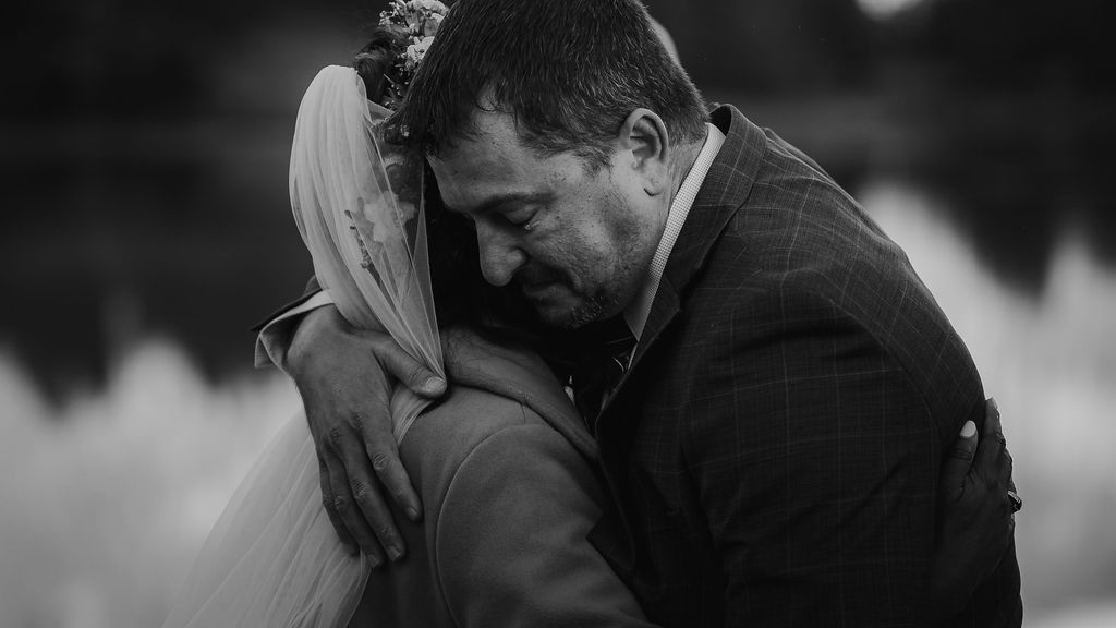 Newlyweds hug tightly by a lake during their crested butte elopement