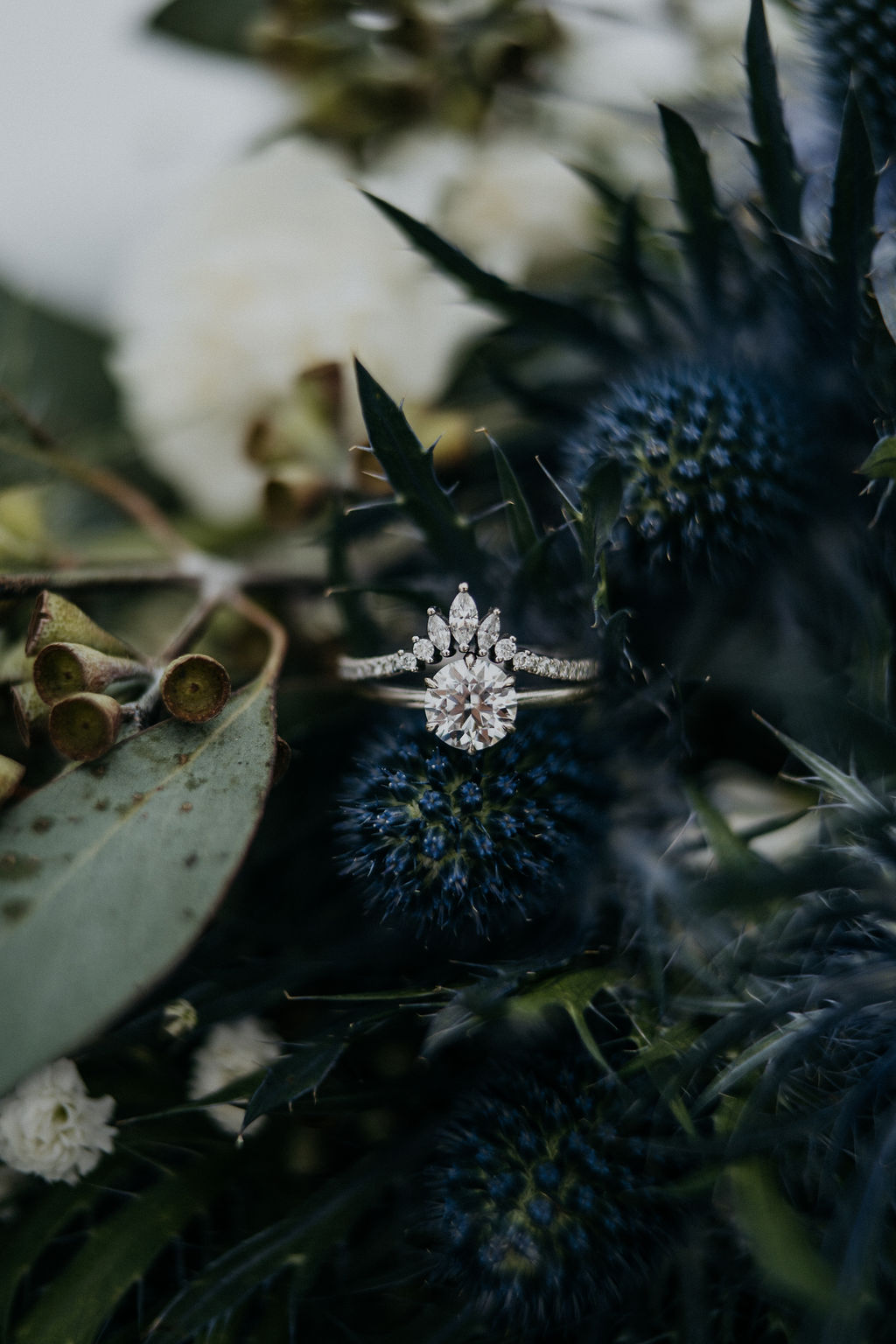 Details of wedding rings sitting on a blue flower