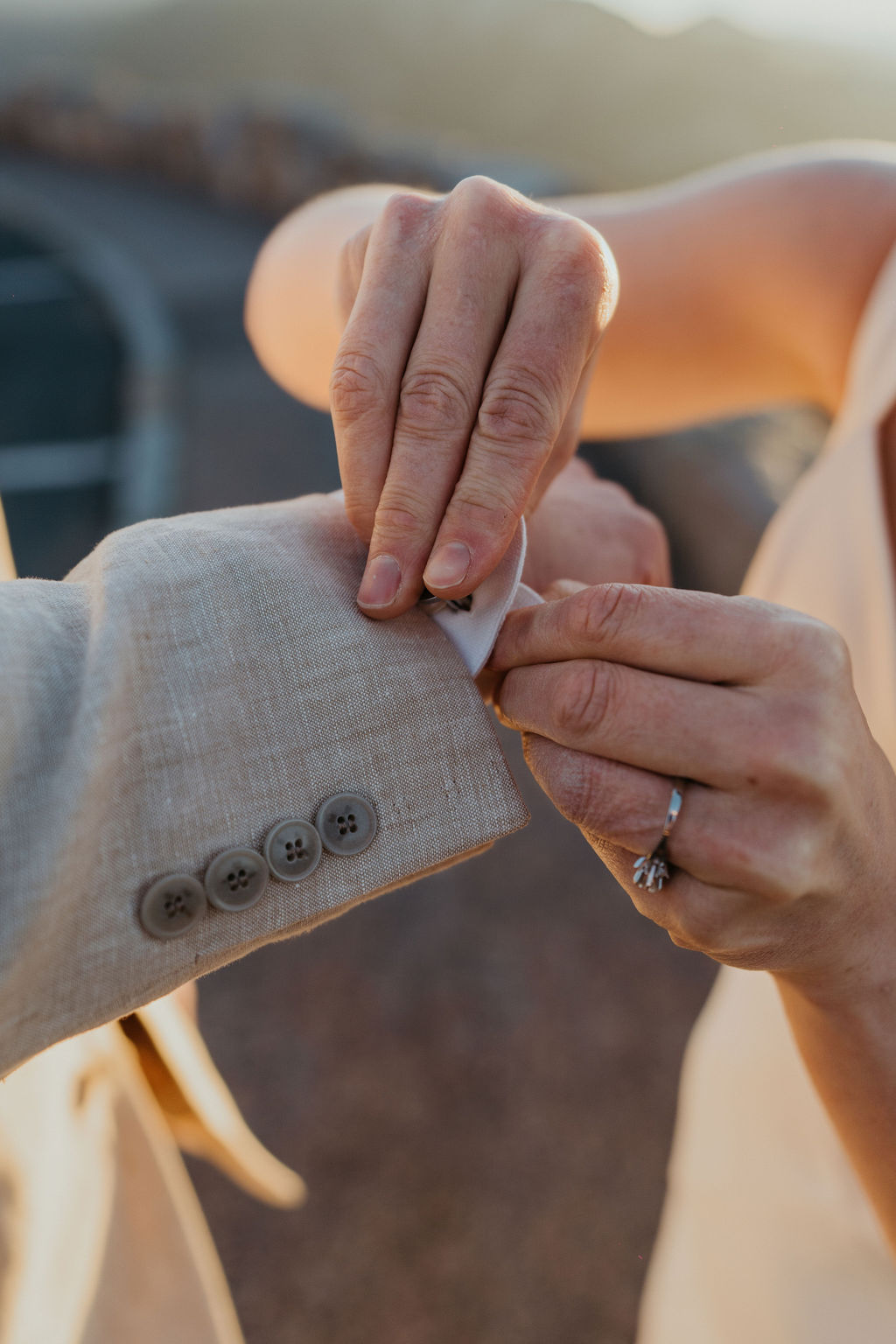 Details of a bride helping her groom with his cufflinks at their estes park elopement