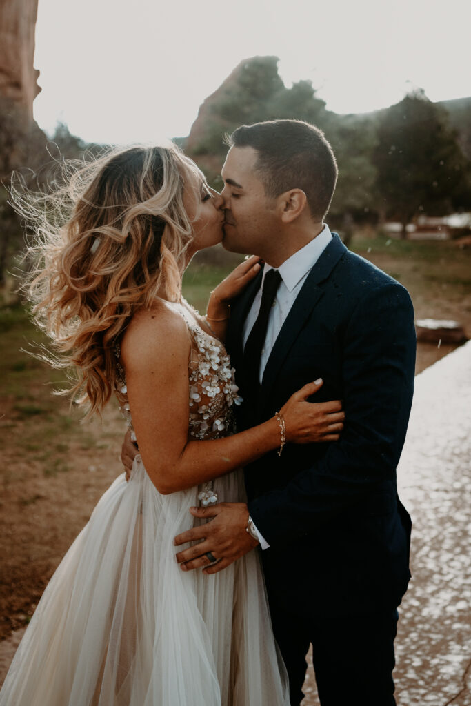 newly weds kiss in the summer rain storm at their garden of the gods elopement 