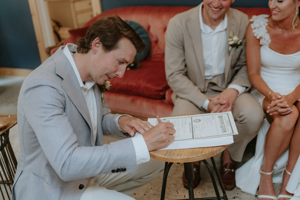 friend of the couple officiated colorado wedding and is signing the marriage license.